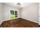 Bright bedroom featuring a large window, hardwood floors, and modern light fixture at 3811 Cottonwood Dr, Durham, NC 27705