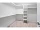 Walk in closet featuring built-in shelving, storage, and neutral carpet at 3811 Cottonwood Dr, Durham, NC 27705