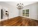 Bright dining room with hardwood floors, chandelier, and large window overlooking the yard at 3811 Cottonwood Dr, Durham, NC 27705