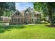 Beautiful two-story brick home with lush green lawn and mature trees providing ample shade at 3811 Cottonwood Dr, Durham, NC 27705
