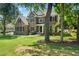 Charming brick home framed by mature trees and a well-maintained lawn with a decorative landscape bed at 3811 Cottonwood Dr, Durham, NC 27705