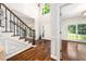 Bright foyer boasts hardwood floors, elegant staircase, wainscoting, and front door with sidelights at 3811 Cottonwood Dr, Durham, NC 27705