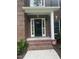 Elegant black front door framed by white columns and sidelights with brick steps at 3811 Cottonwood Dr, Durham, NC 27705