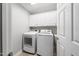Laundry room with modern appliances, white cabinets, and stylish flooring at 3811 Cottonwood Dr, Durham, NC 27705