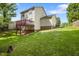 A view of the home's backyard with a raised wood deck and a green lawn at 401 Holly Thorn Trce, Holly Springs, NC 27540