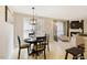Cozy dining area next to the kitchen, featuring a modern chandelier and views of the bright living room at 401 Holly Thorn Trce, Holly Springs, NC 27540