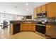 Well-equipped kitchen featuring wooden cabinets, modern appliances, and backsplash with an adjacent dining area at 401 Holly Thorn Trce, Holly Springs, NC 27540