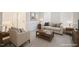Bright living room with neutral tones, plush carpeting, and cozy seating, perfect for relaxing and entertaining at 401 Holly Thorn Trce, Holly Springs, NC 27540