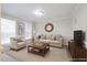 Neutral toned living room featuring plush carpet, two windows, and comfortable furniture for a cozy atmosphere at 401 Holly Thorn Trce, Holly Springs, NC 27540