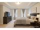 Comfortable main bedroom with neutral walls and linens, traditional wood furnishings, and bright natural light at 401 Holly Thorn Trce, Holly Springs, NC 27540