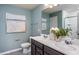 Modern bathroom featuring double sinks, a stylish mirror, and sleek fixtures on blue walls at 414 Grange Farm Pl, Raleigh, NC 27603