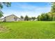 Large, grassy backyard featuring a new home with a walk-out patio with views of the neighborhood at 414 S Center St, Princeton, NC 27569
