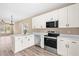 Modern kitchen featuring white cabinets, stainless steel appliances, and an island with sink at 414 S Center St, Princeton, NC 27569