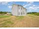 Exterior view of a two-story house with light siding, a patio, and expansive backyard at 44 Chloe Ct, Selma, NC 27576