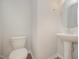 A simple powder room with a pedestal sink and round mirror at 44 Chloe Ct, Selma, NC 27576