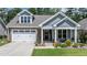 Charming home with brick and siding facade, two-car garage, and landscaped front yard offers delightful curb appeal at 440 Bramble Ln, Clayton, NC 27527