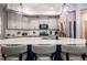 Modern kitchen with gray cabinets, stainless steel appliances, and a stylish island with seating at 440 Bramble Ln, Clayton, NC 27527