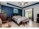 Spacious main bedroom with a sliding glass door, dark wood accents and blue accent wall at 440 Bramble Ln, Clayton, NC 27527