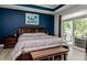 Stylish main bedroom featuring a dark wood accent, sliding glass door and beach themed wall art at 440 Bramble Ln, Clayton, NC 27527