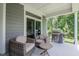 Cozy covered patio with comfortable seating, a convenient grill, and a view of the green backyard at 440 Bramble Ln, Clayton, NC 27527