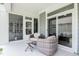 Relaxing covered patio featuring wicker seating, a small table, and access to the outdoors with a sliding glass door at 440 Bramble Ln, Clayton, NC 27527