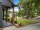 Charming home with manicured lawn, mature trees, and stylish porch columns and a rain chain at 4812 Latimer Rd, Raleigh, NC 27609