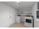 Functional laundry room with modern washer, dryer, shelving, and a bright window at 4812 Latimer Rd, Raleigh, NC 27609