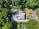 Aerial view of a home with gravel driveway, garden, wooden pergola, and mature trees at 508 N Wake St, Hillsborough, NC 27278
