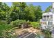Lush backyard featuring garden beds, a chicken coop, and natural surroundings at 508 N Wake St, Hillsborough, NC 27278