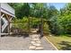 Lush backyard features stone pathways and an arched gate inviting exploration of gardens and seating areas at 508 N Wake St, Hillsborough, NC 27278