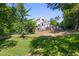 View of the backyard including garden area, trees and lush lawn of this home at 508 N Wake St, Hillsborough, NC 27278