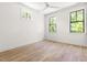 Bedroom with three windows, hardwood floors, and a ceiling fan at 508 N Wake St, Hillsborough, NC 27278