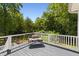 Relax on this lovely outdoor deck with wood floors, white railings and a bench seat with a beautiful view at 508 N Wake St, Hillsborough, NC 27278