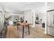 Open-concept dining room with hardwood floors, modern lighting, and stainless steel refrigerator at 508 N Wake St, Hillsborough, NC 27278