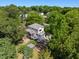 A leafy aerial view shows this home with a charming screened porch and a fenced garden at 508 N Wake St, Hillsborough, NC 27278