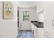 Well-lit laundry room featuring white cabinets, modern sink, and stylish blue patterned floors at 508 N Wake St, Hillsborough, NC 27278