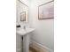 Bright powder room featuring a pedestal sink, neutral walls, and hardwood flooring at 508 N Wake St, Hillsborough, NC 27278