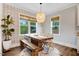 Cozy dining area with a wooden table, bench seating, and stylish light fixtures with natural light from the windows at 52 Summit Overlook Dr, Clayton, NC 27527