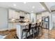 Spacious kitchen boasts white cabinets, stainless steel appliances, a granite island with seating and modern lighting at 52 Summit Overlook Dr, Clayton, NC 27527
