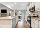 Open kitchen features white cabinets, stainless steel appliances, granite countertops and seamless flow to the dining area at 52 Summit Overlook Dr, Clayton, NC 27527
