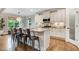 Bright kitchen features white cabinets, granite countertops, stainless steel appliances, and a large island with seating at 52 Summit Overlook Dr, Clayton, NC 27527