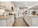 Modern kitchen with white cabinets, granite countertops, stainless steel appliances, and seamless flow to the dining area at 52 Summit Overlook Dr, Clayton, NC 27527