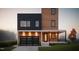 Stunning modern home featuring a unique design with a black and wood facade, a glass garage door, and manicured lawn at 521 Coleman St, Raleigh, NC 27610