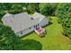Aerial view of backyard with patio furniture on deck, green grass, and a well-maintained gray roof at 5309 Meadow Field Dr, Mebane, NC 27302