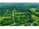 A captivating aerial view of homes nestled within lush greenery and expansive woodland surroundings at 5309 Meadow Field Dr, Mebane, NC 27302