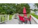 Outdoor deck featuring a gas grill, umbrella, table, and chairs surrounded by lush greenery at 5309 Meadow Field Dr, Mebane, NC 27302