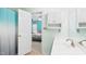 Bright bathroom featuring a white vanity, shower with blue curtain, and an open view into the bedroom at 5309 Meadow Field Dr, Mebane, NC 27302