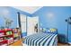 Blue bedroom with a bed with a striped comforter and fun dinosaur decor at 5309 Meadow Field Dr, Mebane, NC 27302