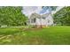 Exterior view of a charming home with a well-maintained lawn, landscaping, and mature trees at 5309 Meadow Field Dr, Mebane, NC 27302