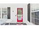 Charming front porch with a red-framed glass door, dark shutters, and a cozy rocking chair and table at 5309 Meadow Field Dr, Mebane, NC 27302